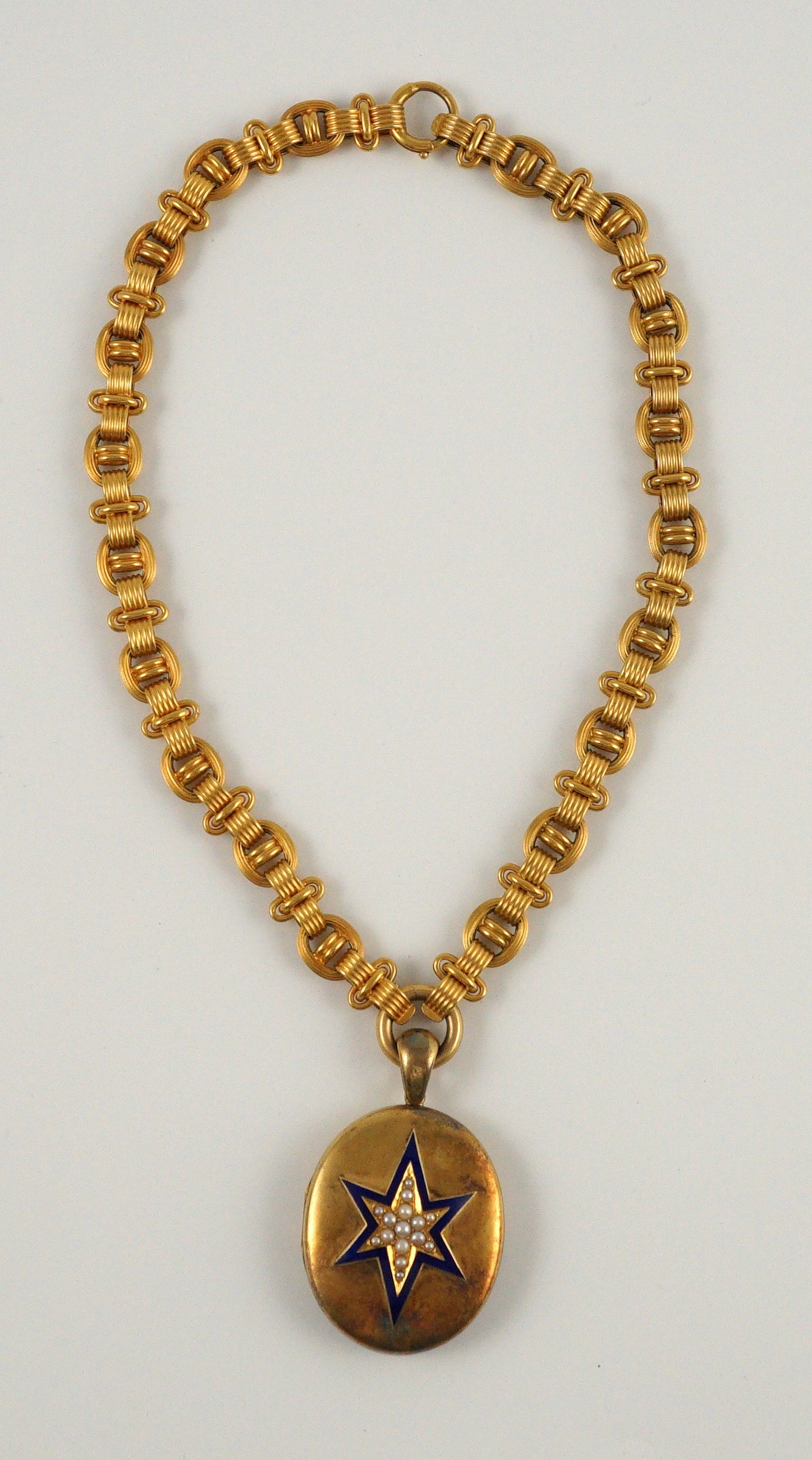 A Victorian gold, enamel and seed pearl set oval locket, on a 19th century Vienna 580/1000 gold chain